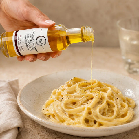 Olivový olej s černým lanýžem pokapaný přes teplé krémové tagliatelle